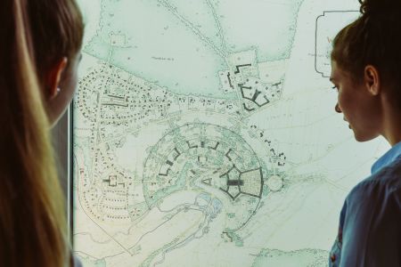 Gäste der Wewelsburg schauen sich die Baupläne aus dem Zweiten Weltkrieg an